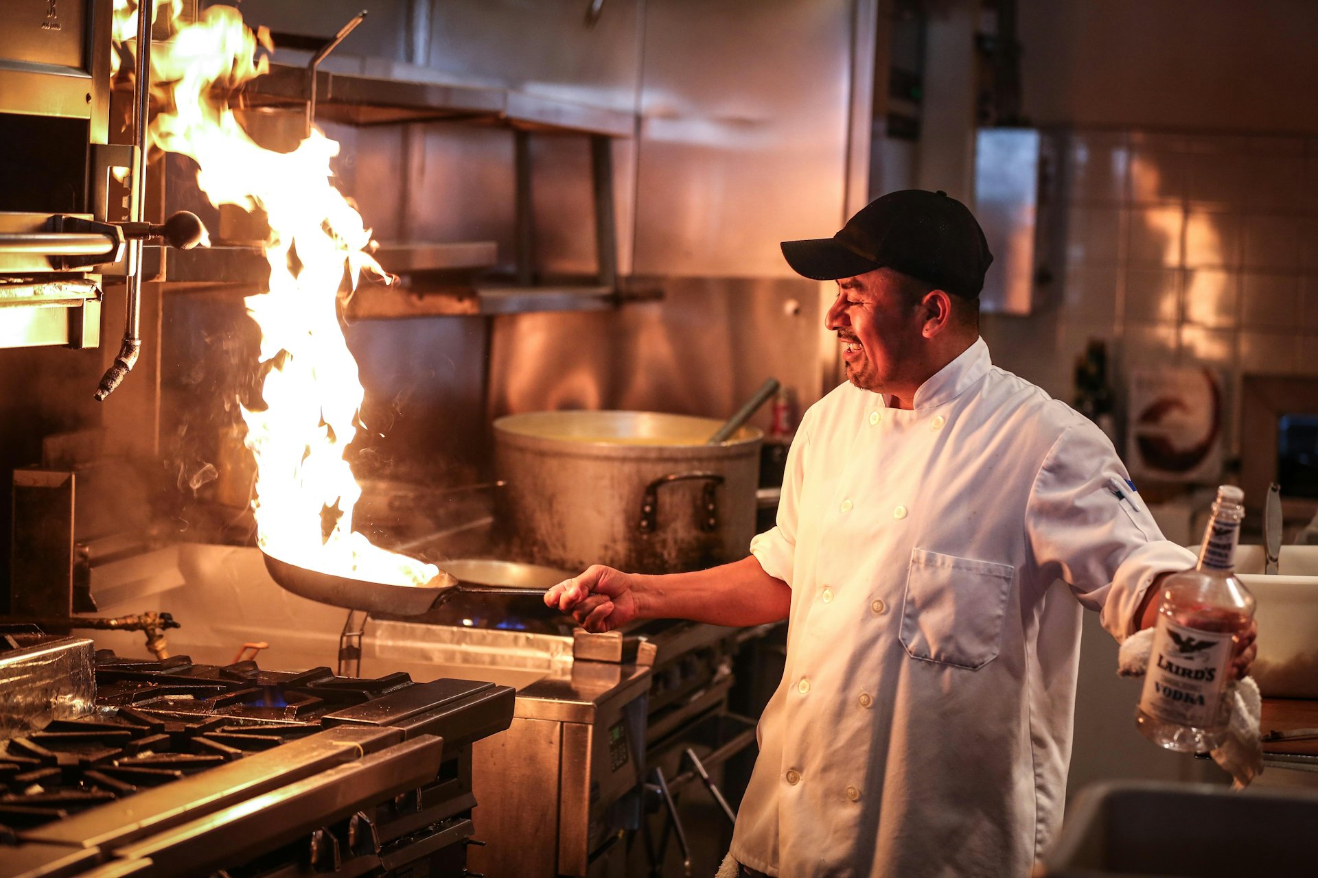 Un cuisinier devant une flamme vive, en cuisine