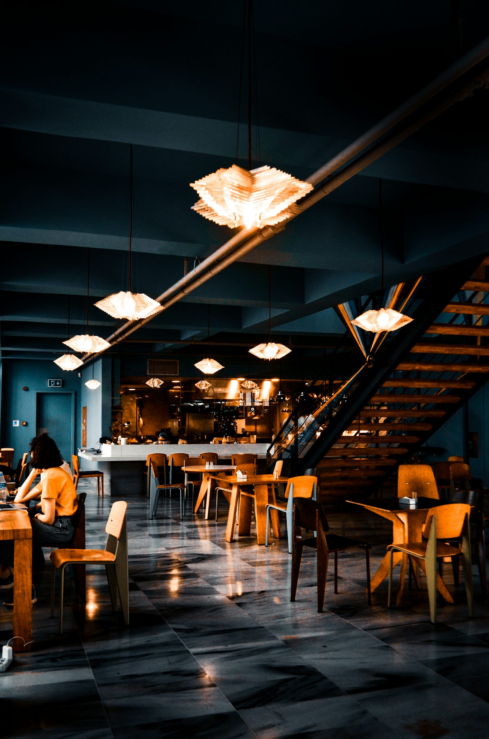 La salle le soir, lumières basses et bar en bois